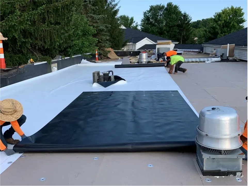 Crew installing a TPO roofing membrane on the Cherry Valley Hotel project
